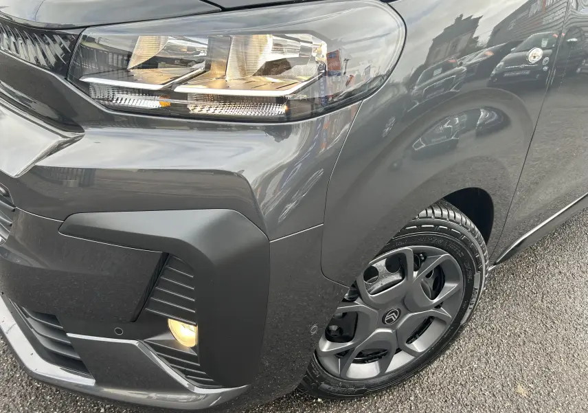 Gros plan sur l'avant droit gris titane métallisé du Citroën Jumpy Cabine Approfondie avec phare et jante distinctive.