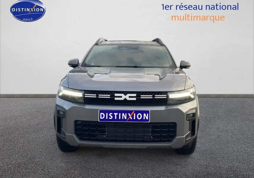 Vue avant du Dacia Bigster gris schiste 2025 avec calandre noire et phares LED allumés.