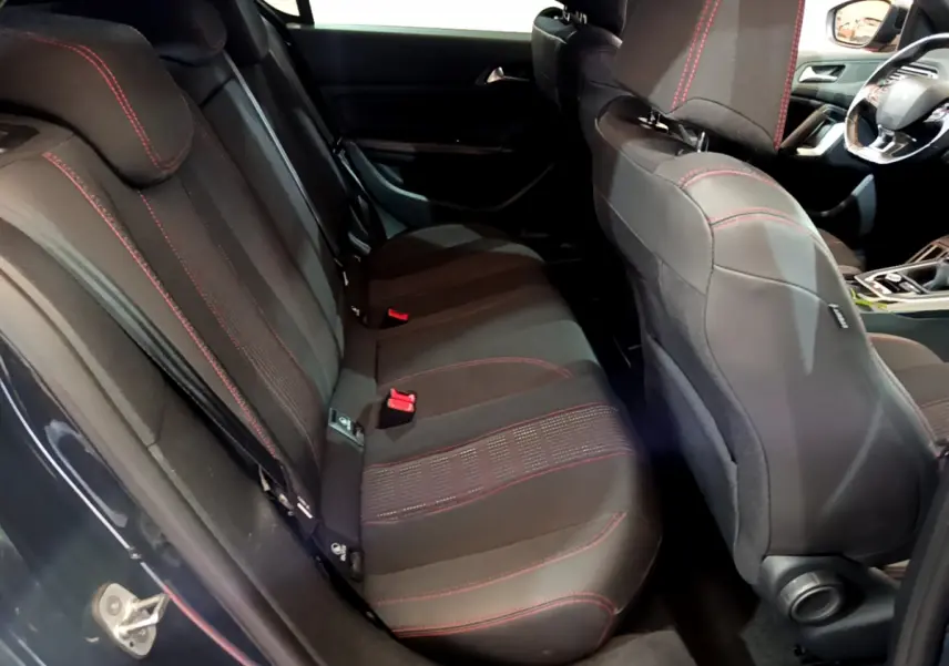 Vue intérieure côté gauche montrant la banquette arrière noire avec surpiqûres rouges de la Peugeot 308 GT Line 2016.