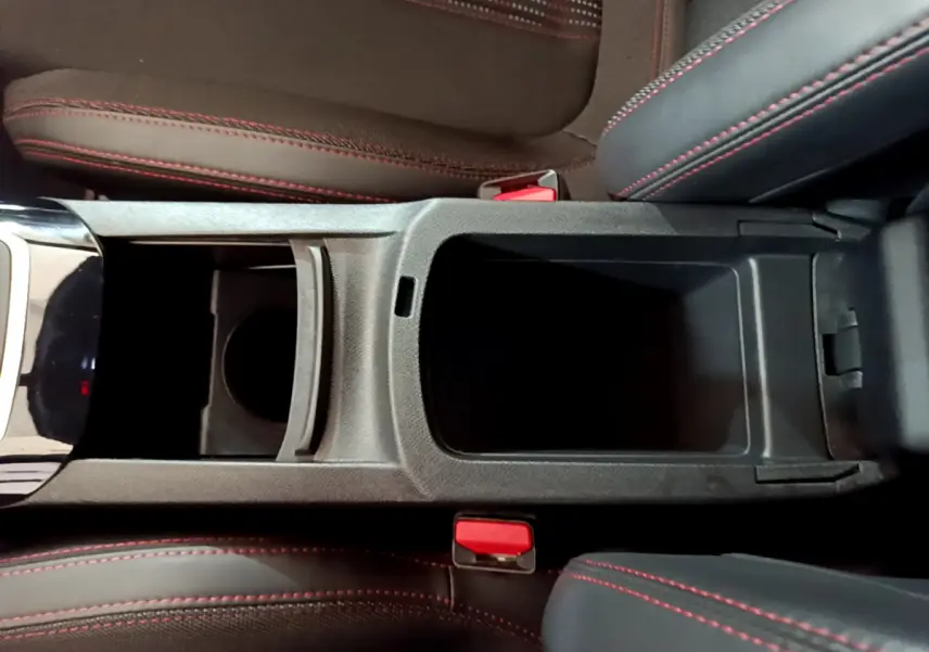 Vue plongeante sur la console centrale ouverte de la Peugeot 308 GT Line 2016, sièges noirs avec surpiqûres rouges visibles.