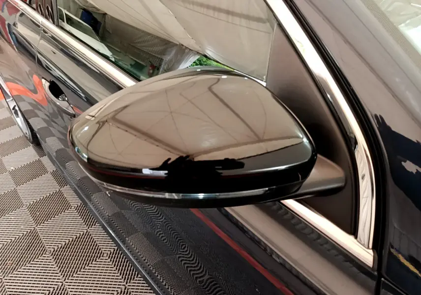 Gros plan sur le rétroviseur droit gris foncé brillant de la Peugeot 308 GT Line 2016, avec reflet de l’environnement.