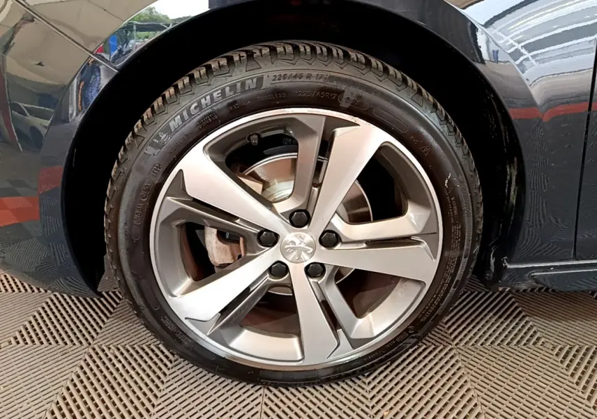 Gros plan sur la roue avant droite grise métallisée d'une Peugeot 308 GT Line 2016 avec jante alliage cinq branches.