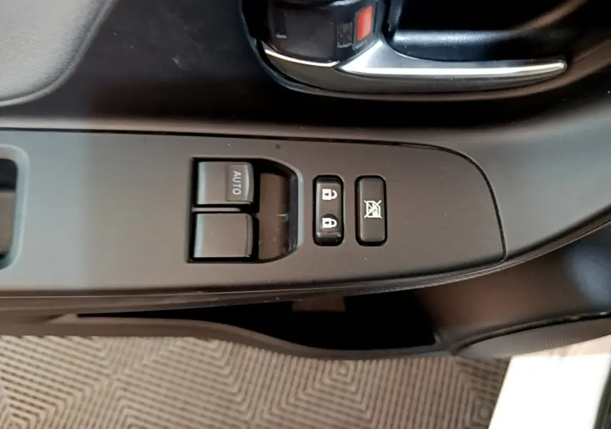 Gros plan sur la commande des vitres et verrouillage côté gauche intérieur d’une Toyota Yaris blanche 2019.