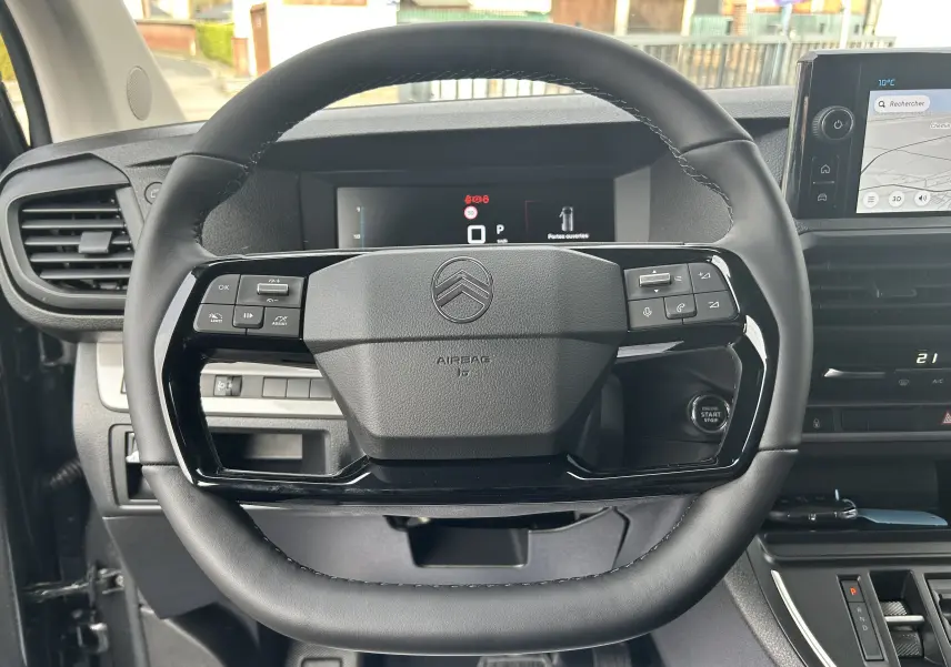 Vue rapprochée du volant noir du Citroën Jumpy Cabine Approfondie 2025 avec commandes intégrées et tableau de bord numérique.