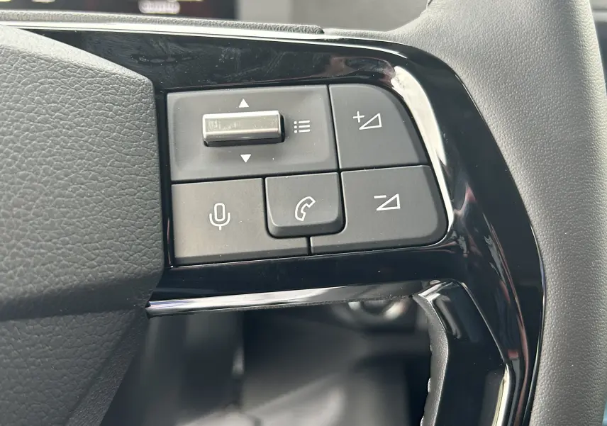 Gros plan sur les commandes du volant à gauche du Citroën Jumpy Cabine Approfondie gris titane, boutons de volume et téléphone.