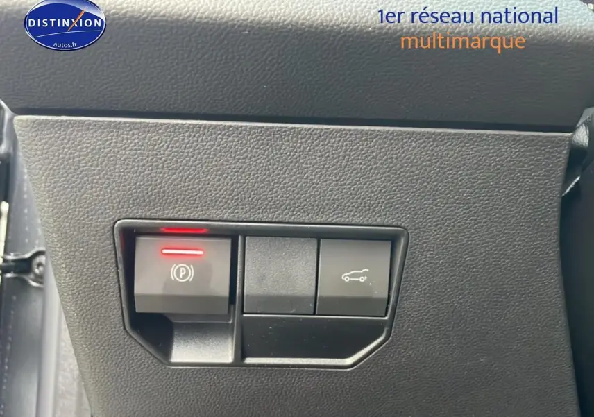 Gros plan sur les commandes intérieures du tableau de bord du Dacia Bigster gris schiste, avec bouton de frein à main électronique.