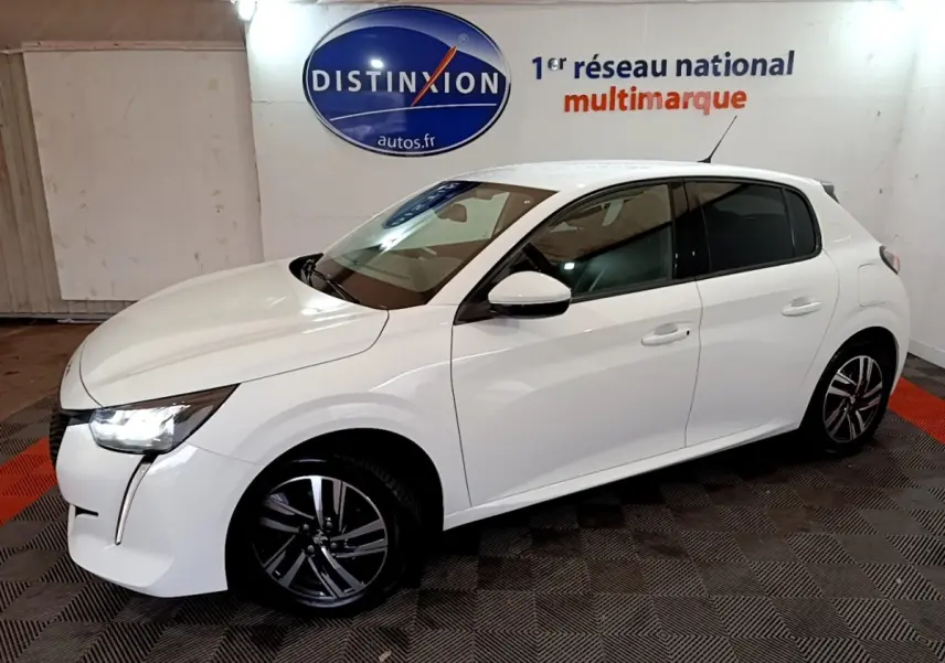 Peugeot 208 blanc vue de côté droit en intérieur, avec phares LED allumés et jantes alliage noires.