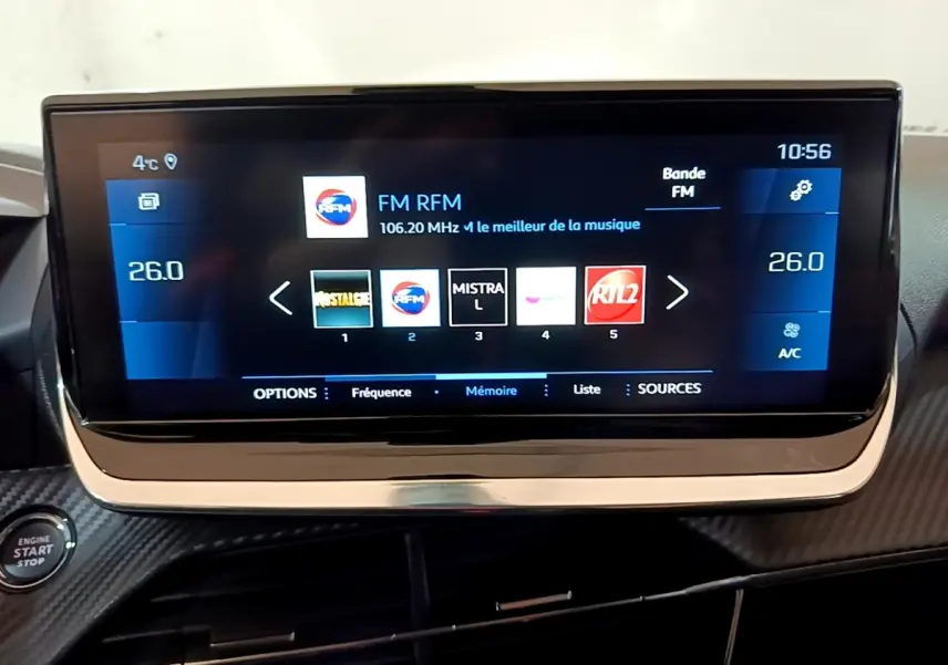 Écran tactile central de 10 pouces de la Peugeot 208 blanche, affichant la radio FM avec interface moderne.