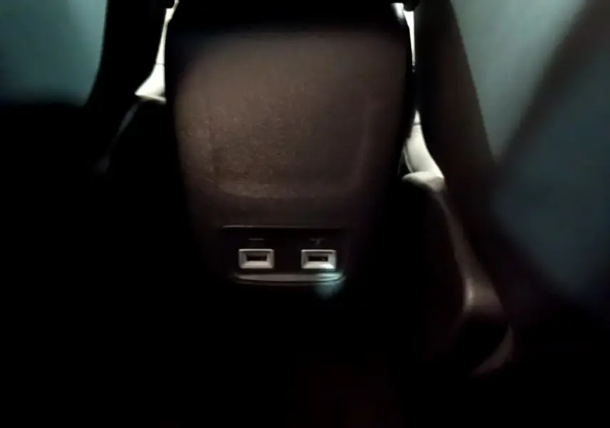Prise USB double vue de près à l'arrière de la console centrale d'une Peugeot 208 blanche 2021.