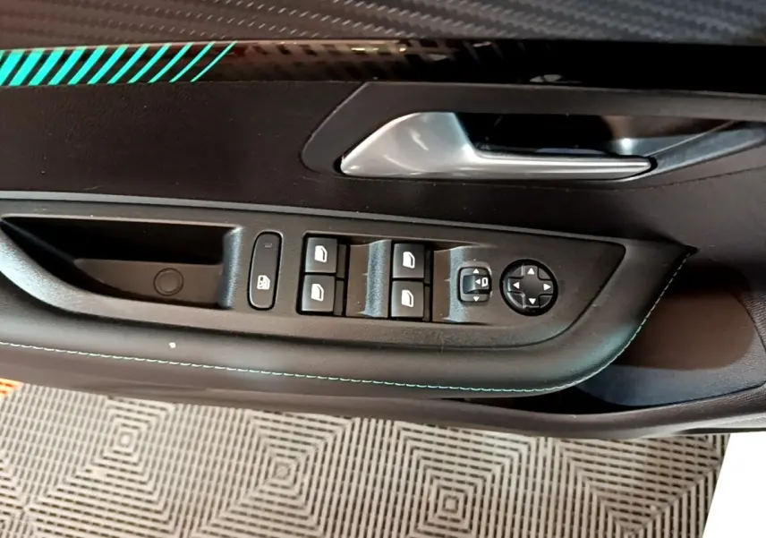 Gros plan sur la commande des lève-vitres et rétroviseurs côté gauche intérieur de la Peugeot 208 blanche 2021.