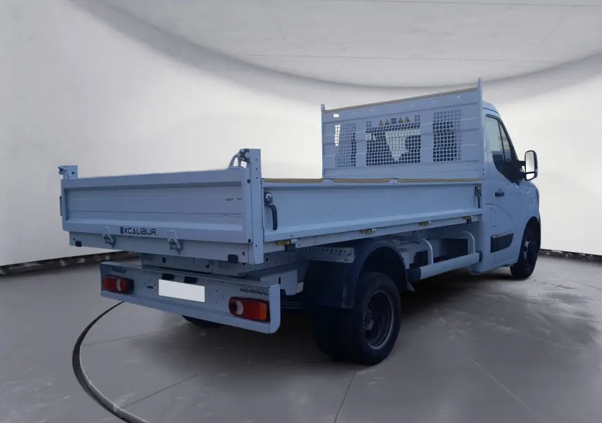 Renault Master Benne blanc vu 3/4 arrière droit avec ridelle et roues jumelées dans un studio.