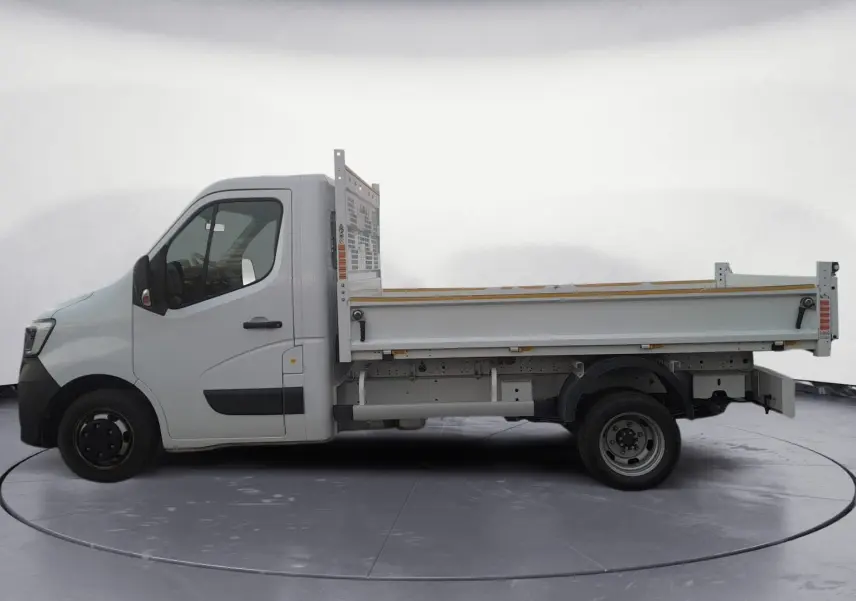 Profil gauche d’un Renault Master Châssis Cabine blanc 2024 avec benne et roues jumelées, sur fond neutre.