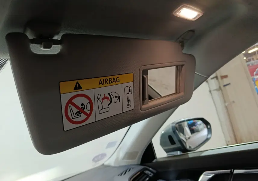 Pare-soleil côté conducteur avec miroir intégré et avertissement airbag dans l'Audi Q3 Sportback gris foncé, vue intérieure avant droite.