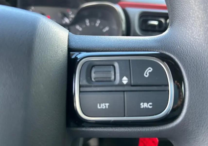 Gros plan sur les commandes audio au volant noir de la Citroën C3 1.2 PureTech Sable Metal 2021.