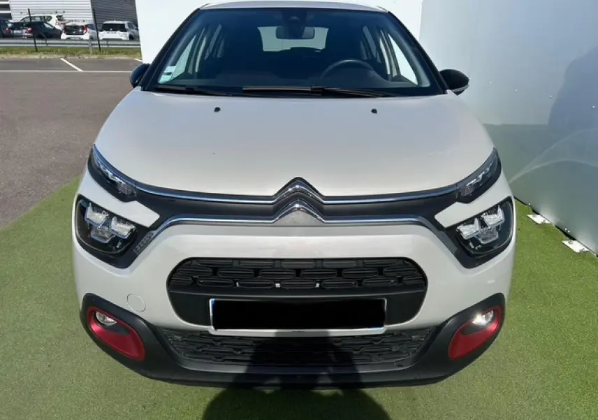 Vue frontale d'une Citroën C3 1.2 PureTech 83 S&S C-Series sable métal avec inserts rouges sur le pare-chocs.