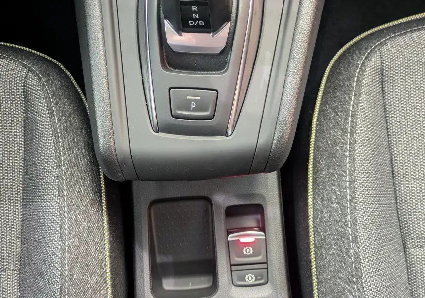 Vue rapprochée du levier de vitesses automatique et frein de parking électronique entre les sièges tissu gris du Renault Captur 2025.