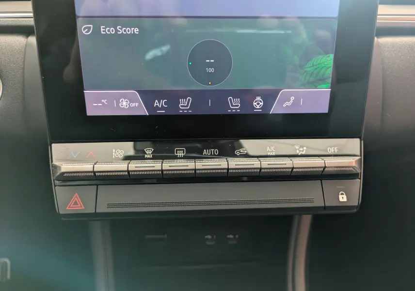 Vue rapprochée du tableau de bord tactile et des commandes de climatisation du Renault Captur E-Tech gris Cassiopée 2025.