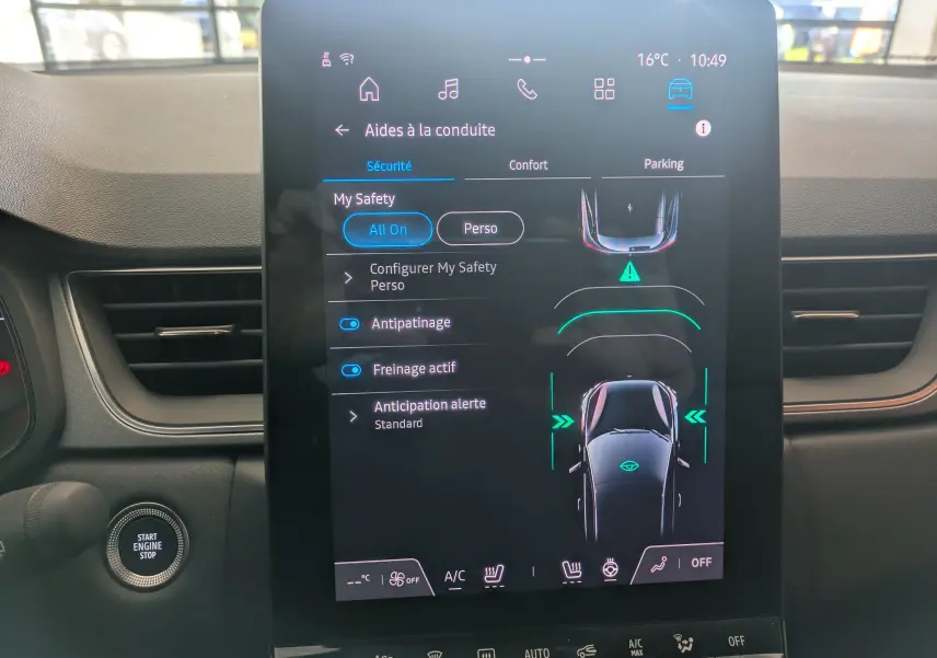 Écran tactile central affichant les aides à la conduite dans l’habitacle du Renault Captur gris Cassiopée, vue de face.