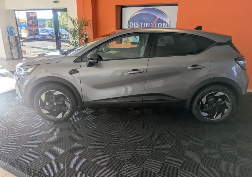 Profil côté gauche du Renault Captur E-Tech Full Hybrid 160 en gris Cassiopée avec jantes alliage 18'' Blackhole en showroom.