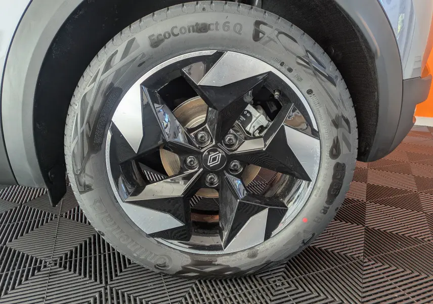 Gros plan sur la jante alliage 18'' Blackhole noire et argent du Renault Captur gris Cassiopée, roue avant droite visible.