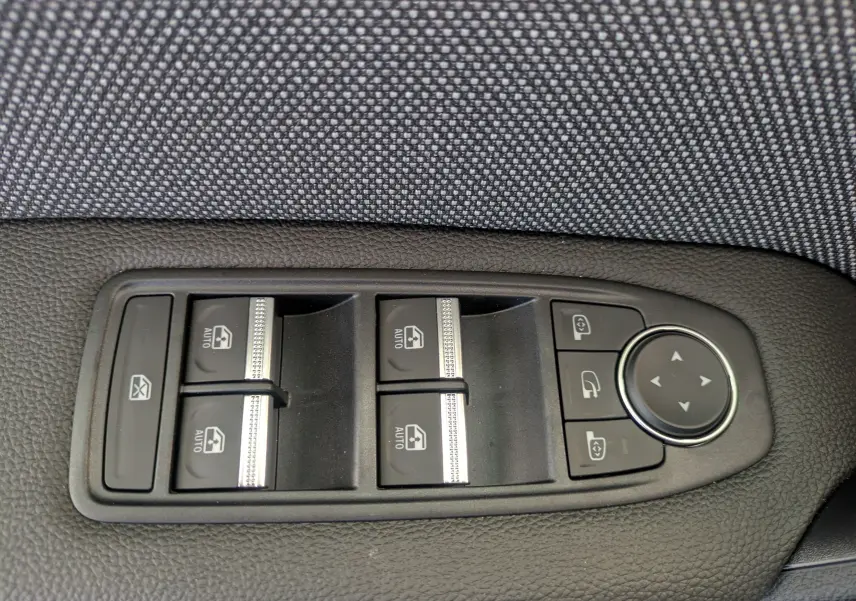 Panneau de commandes des vitres électriques et rétroviseurs sur la porte intérieure d'un Renault Captur gris Cassiopée.