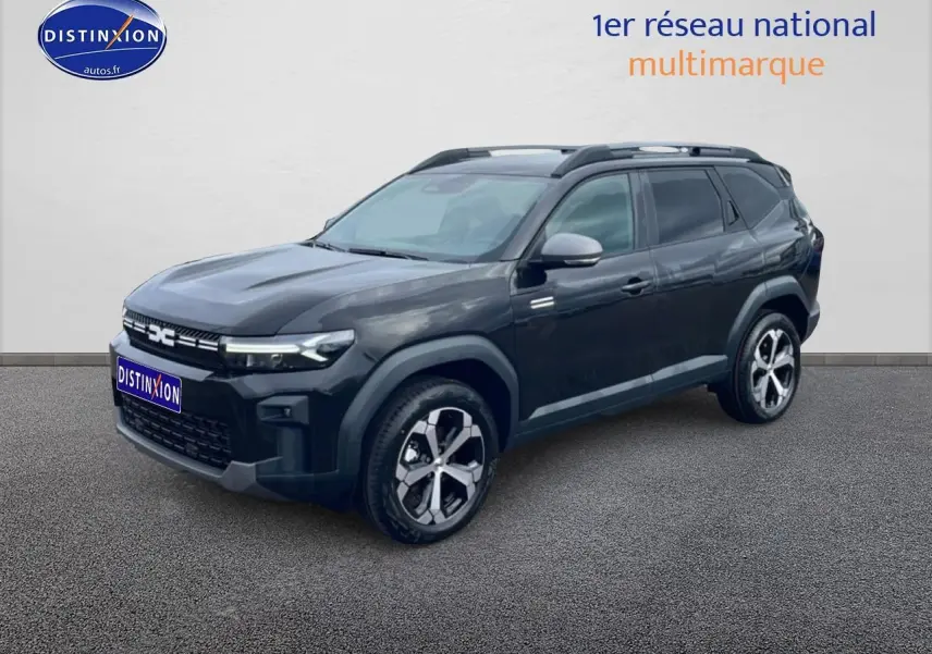 SUV Dacia Bigster noir en 3/4 avant droit, avec jantes alliage diamantées et barres de toit visibles.
