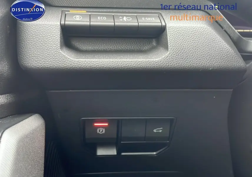 Gros plan sur les commandes intérieures noires du tableau de bord du Dacia Bigster 2025, avec bouton frein à main électronique allumé.