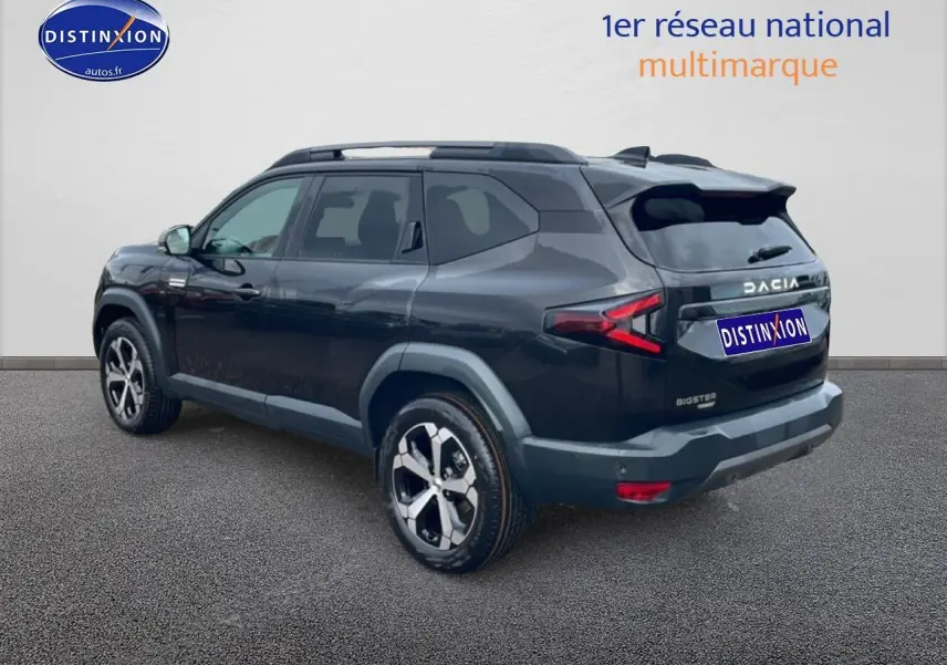 Vue 3/4 arrière droite du SUV Dacia Bigster noir 2025 avec jantes alliage diamantées et barres de toit.