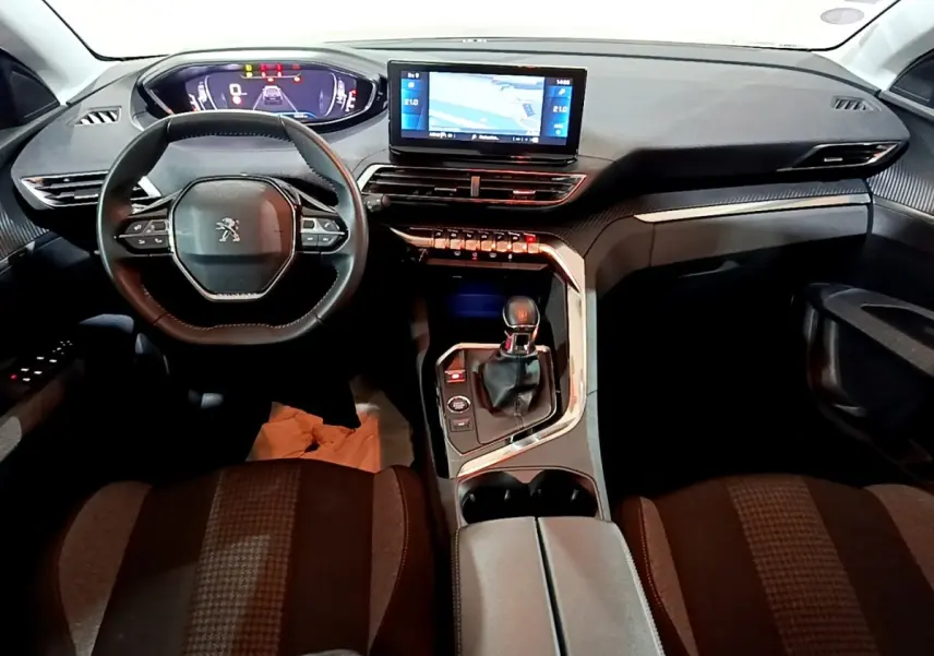 Vue intérieure avant du Peugeot 5008 noir 2021, tableau de bord avec écran tactile central et volant compact multifonctions.