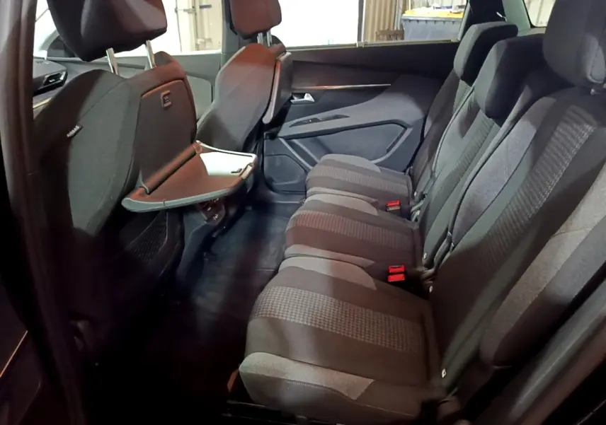 Vue intérieure côté droit des sièges arrière gris foncé du Peugeot 5008 2021 avec tablette rabattable sur dossier avant.