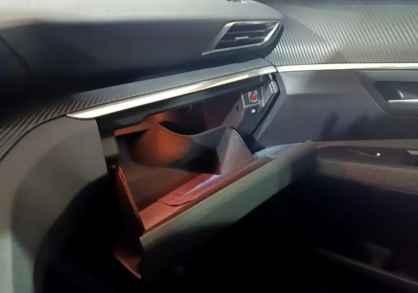 Intérieur Peugeot 5008 2021 noir, vue du rangement ouvert côté passager avec tableau de bord texturé.
