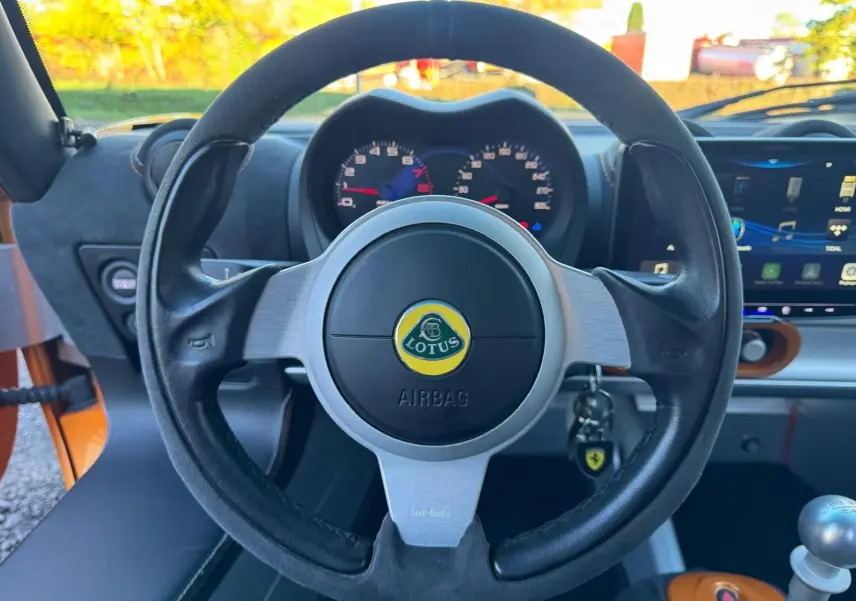 Vue centrée sur le volant cuir noir de la Lotus Elise 3 Cup 250 2021 avec tableau de bord et levier de vitesses alu visible.