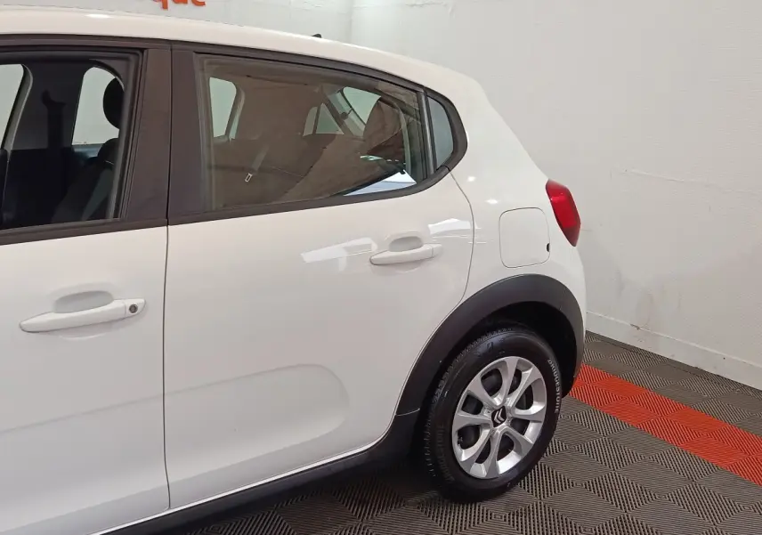 Vue côté droit arrière d'une Citroën C3 blanche 2020 avec jantes alliage et protections noires sur les passages de roues.
