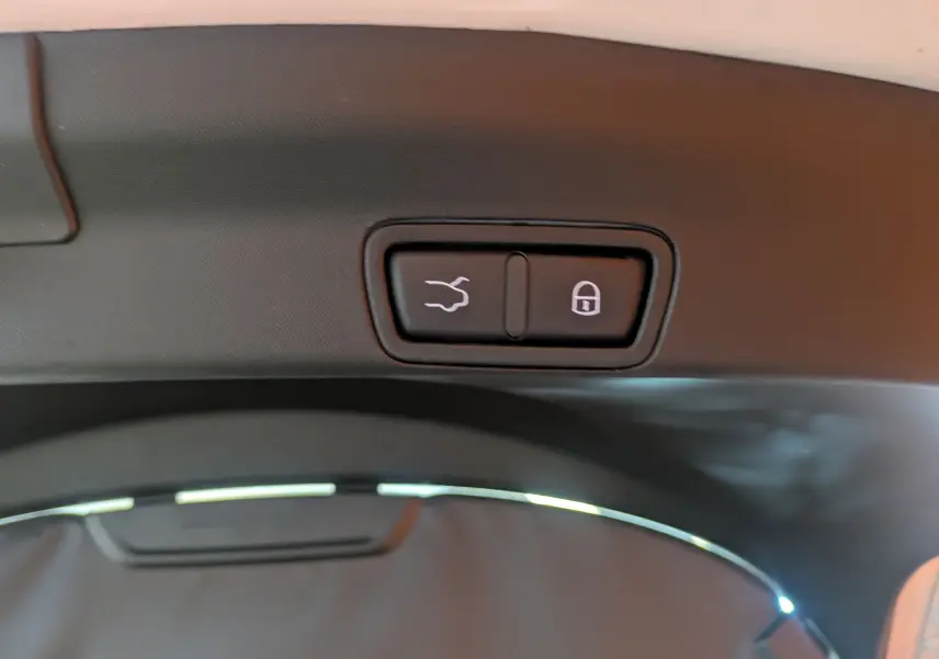 Boutons d'ouverture et de verrouillage du hayon sur la garniture intérieure d'un Alfa Romeo Stelvio blanc 2023.