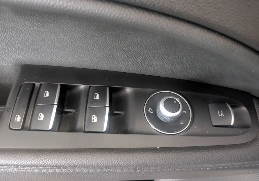 Panneau de commandes des vitres et rétroviseurs côté gauche intérieur d'un Alfa Romeo Stelvio blanc 2023 Sprint.