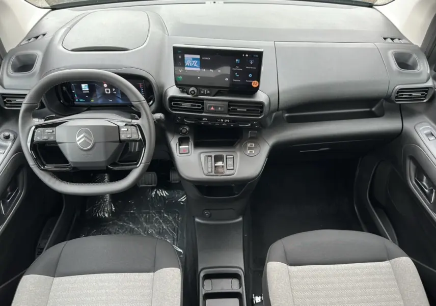 Vue intérieure du tableau de bord du Citroën Berlingo 2025, avec volant multifonction et écran tactile central.