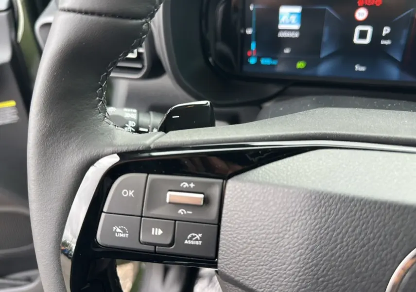 Gros plan sur le volant cuir du Citroën Berlingo 2025 avec commandes intégrées et tableau de bord numérique.