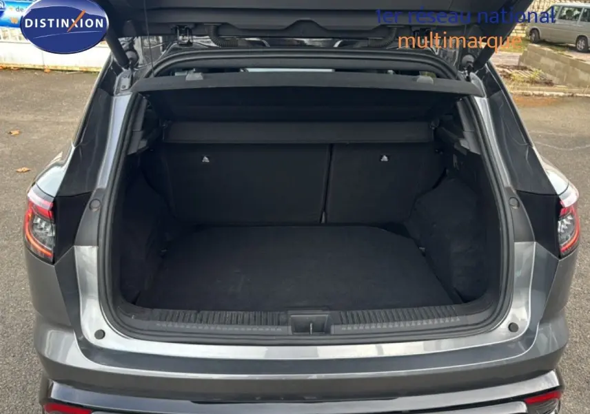 Coffre ouvert en vue arrière d'un Renault Austral gris schiste avec toit noir, montrant l'espace de chargement vide.
