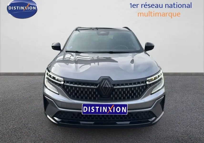 Vue frontale d'un Renault Austral gris schiste avec toit noir, calandre noire à motifs et phares LED distinctifs.