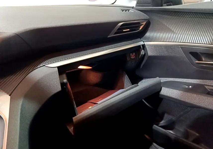 Vue intérieure côté passager du Peugeot 3008 gris clair 2020, boîte manuelle, avec boîte à gants ouverte et tableau de bord texturé.