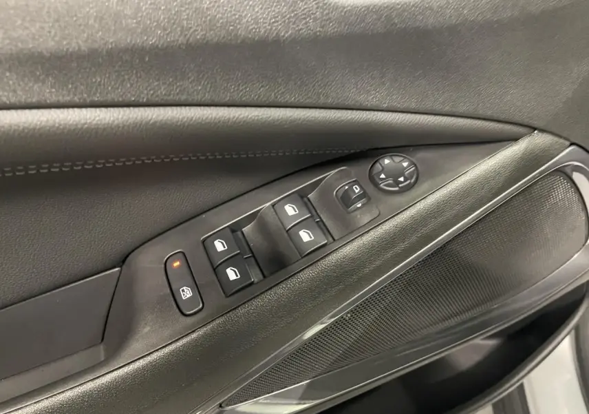 Détail des commandes de lève-vitres et rétroviseurs sur la porte avant gauche d’un Opel Crossland gris clair.