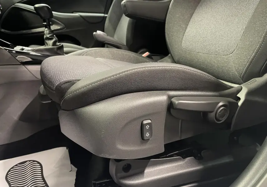 Gros plan sur le siège conducteur gris foncé de l’Opel Crossland 2024 avec commande de réglage manuel et levier d’accoudoir.