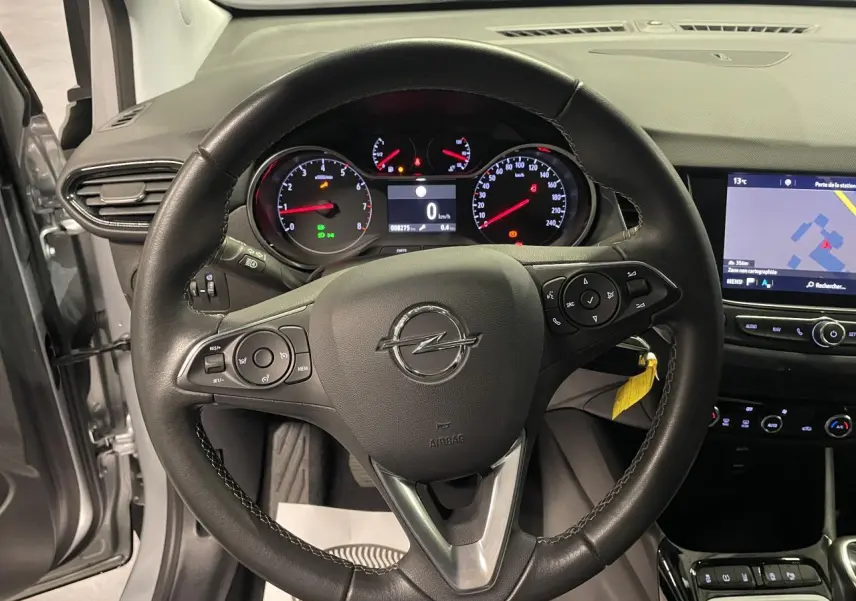 Vue intérieure centrée sur le volant cuir noir d’Opel Crossland gris clair avec tableau de bord et écran tactile visible.