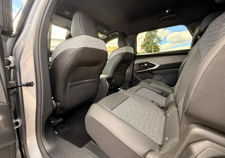 Vue intérieure côté gauche des sièges arrière du Peugeot 5008 Hybrid 145 finition Allure, avec sellerie bi-matière grise et noire.