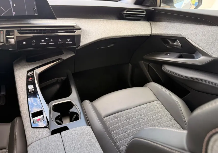 Vue intérieure côté passager du Peugeot 5008 Hybrid 145 finition Allure, avec sellerie grise et console centrale moderne.
