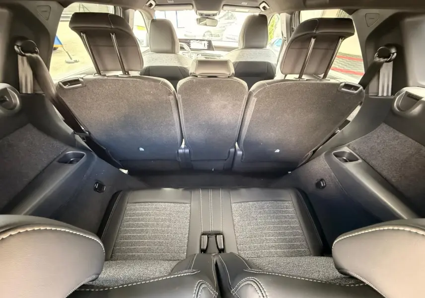 Vue intérieure du coffre du Peugeot 5008 Hybrid 145 gris Artense, sièges arrière relevés et banquette en tissu et cuir.