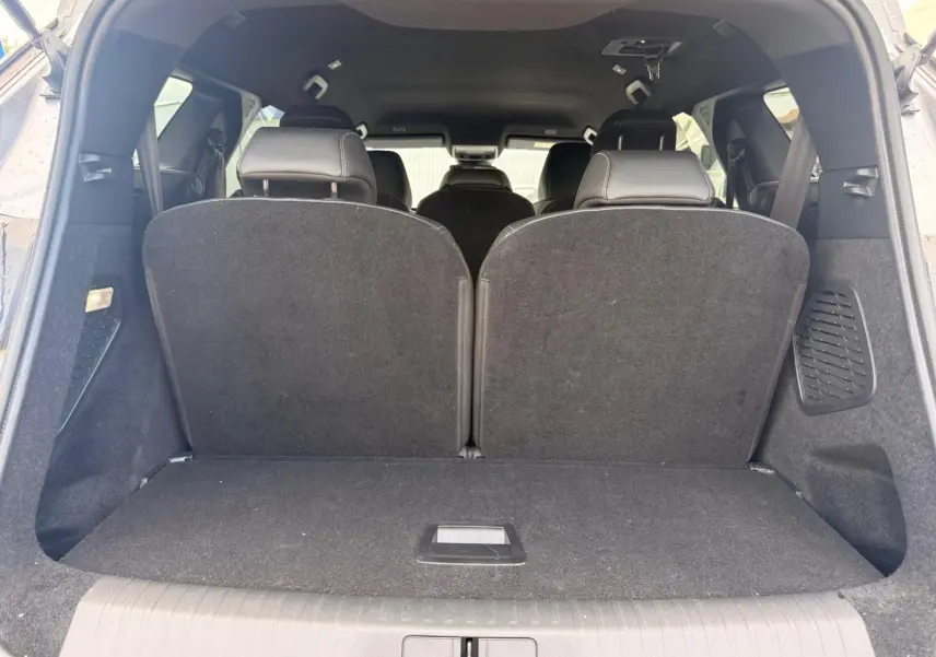 Vue arrière du coffre du Peugeot 5008 gris Artense, montrant les sièges arrière relevés et l'espace de chargement fermé.