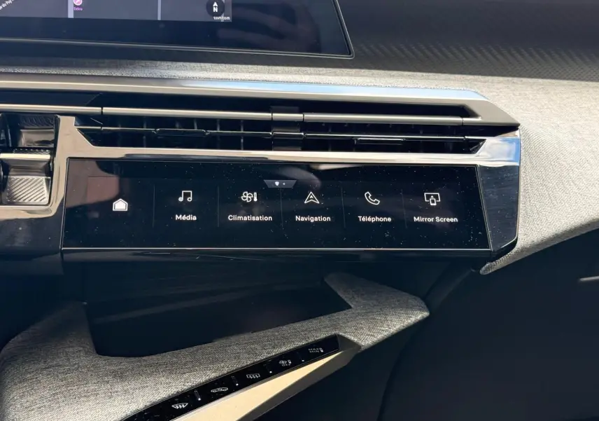 Vue rapprochée de la console centrale tactile noire du Peugeot 5008 gris Artense, affichant les commandes multimédia et climatisation.