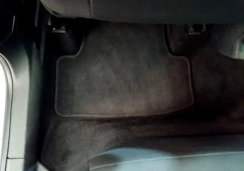 Vue rapprochée du tapis de sol noir côté conducteur dans un Skoda Karoq gris clair 2022.