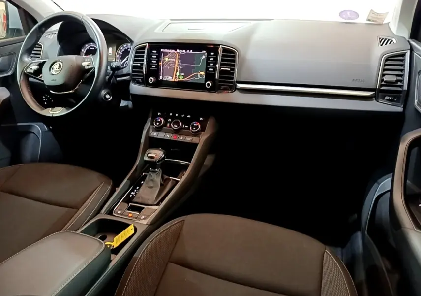 Vue intérieure du tableau de bord et console centrale du Skoda Karoq 2022 avec écran tactile et volant multifonctions.